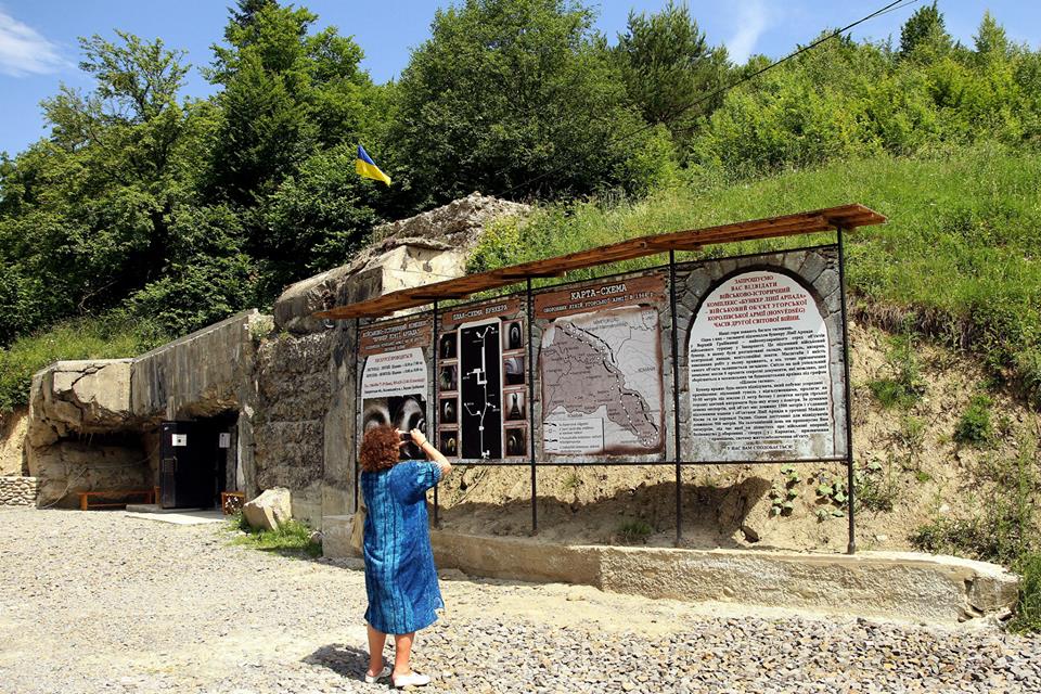 Egy látogató fényképezi a tájékoztató táblát a második világháborús Árpád-vonal bejáratánál a Kárpátokban, a Volóci járásban található Felsőgereben határában 2013. június 16-án.