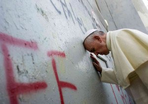 Ferenc pápa megérinti a falat, amely elválasztja a palesztin területet Izraeltől.