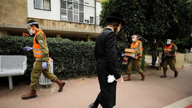 Az izraeli katonák élelmiszereket szállítanak egy Tel-Aviv melletti ultra ortodox zsidó városban, amelyet a koronavírus súlyosan sújt. © Reuters / Amir Cohen